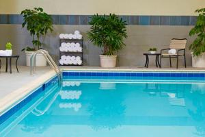 a swimming pool with two chairs and a table next to it at Marriott Birmingham Grandview in Acton