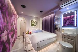 a small bedroom with a bed and a sink at Hotel CARA 大人専用Adult only hotel in Tokyo
