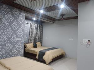 Postel nebo postele na pokoji v ubytování Radhika Hotel