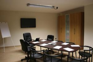 a conference room with a table and black chairs at Hotel Cavour in Rieti