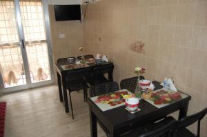 Borghesiana にあるB&B Il Saliceの食べ物を置いた部屋のテーブルと椅子2つ