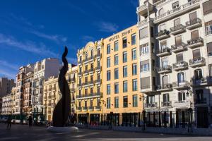 a large building with a statue in front of it at Zenit Valencia in Valencia