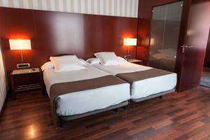 a bedroom with a large bed and two lamps at Zenit Valencia in Valencia