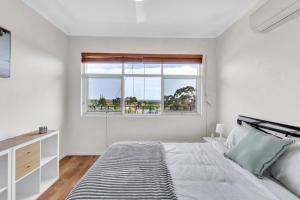 a white bedroom with a bed and a window at Charming Modern Retreat with Scenic View - Burnside in Burnside