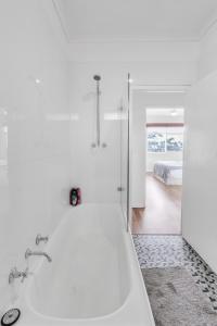 a white bathroom with a tub and a bedroom at Charming Modern Retreat with Scenic View - Burnside in Burnside