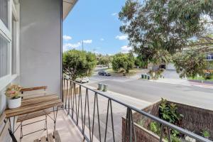a balcony with a bench and a view of a street at Walk to Beach And Cafes Near City And Airport in West Beach
