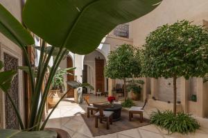 cortile con tavoli, sedie e piante di Riad Nomada Marrakech a Marrakech