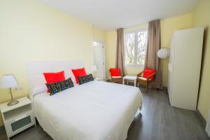 a bedroom with a large white bed with red pillows at Hotel Valle del Oja in Casalarreina