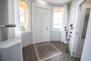 un pasillo con una puerta blanca con ventanas y una alfombra en Hotel Valle del Oja, en Casalarreina