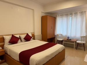 a hotel room with a large bed with red pillows at Zipp Lite - HAL Old Airport Road in Bangalore