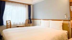 Postel nebo postele na pokoji v ubytování Toyoko Inn Tsuruga Ekimae