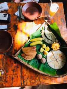 ein Teller mit Essen auf einem Holztisch in der Unterkunft Sigiriya Coconut Shade Resort in Sigiriya + 33 Fotos