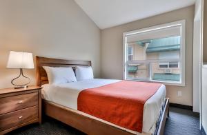 a small bedroom with a bed and a window at Mountain Surrounded Lodge in Harvie Height in Canmore
