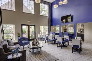 a waiting room at a hospital with chairs and tables at Guesthouse Inn & Suites Lexington in Lexington