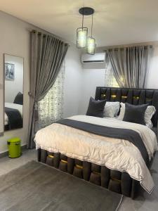 Steph Apartment في أبوجا: غرفة نوم بسرير كبير مع لوح أمامي أسود