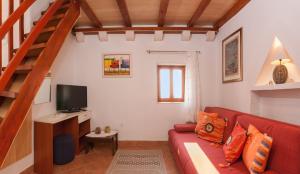 a living room with a red couch and a television at Holiday Home Vineyard House in Bol