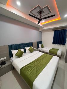 a bedroom with two beds and a ceiling fan at HOTEL RK VILLA , Naroda in Ahmedabad