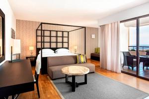 a bedroom with a bed and a couch and a table at Sheraton Rhodes Resort in Ixia