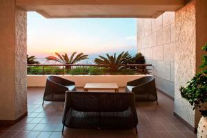 a patio with chairs and a table with a view at Sheraton Rhodes Resort in Ixia