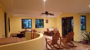a living room with a ceiling fan and chairs at Hostal Bocas Tropical Paradise in Bocas Town