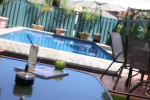 a table with an apple on it next to a swimming pool at Adelaide International Motel in Adelaide