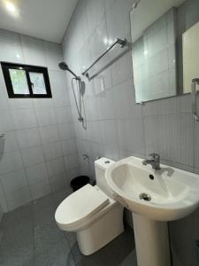 a white bathroom with a toilet and a sink at J&K Sunrise in El Nido