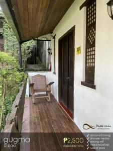 a porch of a house with a chair and a door at Panaad Garden in Tagaytay +4 photos
