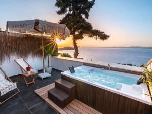 a hot tub on a deck with a view of the ocean at Hillora Hotel Buyukada in Adalar