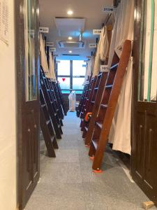 a aisle of a library with a person walking down the aisle at Hostel Lodging Tokyo Ueno in Tokyo