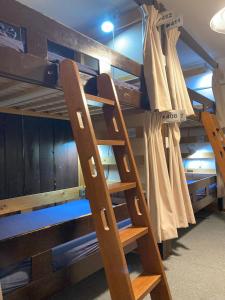 a wooden ladder in a room with bunk beds at Hostel Lodging Tokyo Ueno in Tokyo