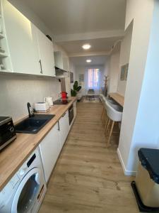 a kitchen with a sink and a washing machine at Coeur de ville - Appartement 2 chambres in Amiens +5 photos