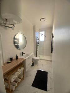 a white bathroom with a toilet and a mirror at Coeur de ville - Appartement 2 chambres in Amiens