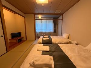 Letto o letti in una camera di 南紀月の瀬温泉ぼたん荘
