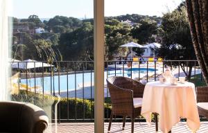 リャフランにあるHotel BlauMar Llafrancのプールを望むバルコニー(テーブル、椅子付)