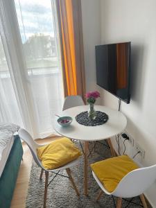 Apartman Krčmar Divcibare في ديفشيبار: طاولة بيضاء صغيرة مع كرسيين وتلفزيون