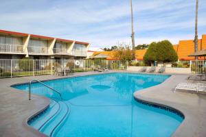 a swimming pool at a resort with chairs and a building at Travelodge by Wyndham Monterey Bay in Monterey