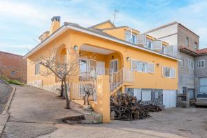 ein gelbes Haus mit einer Treppe davor in der Unterkunft La Casona in Chera