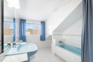 ein Badezimmer mit einer blauen Badewanne und einem Waschbecken in der Unterkunft La Casona in Chera + 26 Fotos