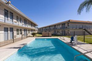 a swimming pool in front of a building at Days-Inn by Wyndham Bakersfield in Bakersfield