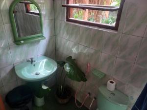 un bagno con lavandino, specchio e pianta di Oops a Unawatuna