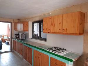 a kitchen with wooden cabinets and a stove top oven at Farmhouse on an olive grove in Siġġiewi