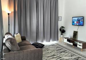 un salon avec un canapé et une télévision dans l'établissement IRIS 33 Corner Lot House Spacious Outdoor Malay Only, à Skudai