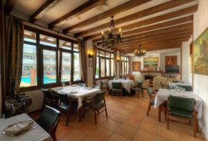 a dining room with tables and chairs and windows at Hotel Porfirio in Zahara de los Atunes