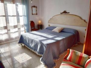 a bedroom with a bed with a blue blanket at Grande appartamento con giardino uso esclusivo, posto auto, barbecue, aria condizionata in Cecina