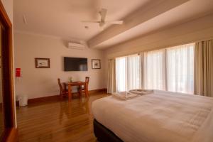 a bedroom with a bed and a table and a television at Birdwood Motel in Birdwood
