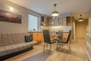 sala de estar con sofá, mesa y sillas en Sail to Gdynia Apartment en Gdynia