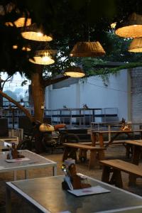a restaurant with wooden tables and trees and lights at Unplanned Hostel Udaipur in Udaipur