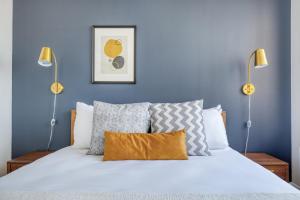 a bedroom with a white bed with blue walls at Tribeca Studio w Gym Indoor pool NYC-184 in New York +19 photos