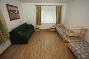 a living room with a green couch and a table at Leśniczówka Wigierskiego Parku Narodowego w Maćkowej Rudzie in Krasnopol