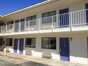 un edificio de apartamentos con balcón y puertas azules en Motel 6 - Pensacola West, en Pensacola